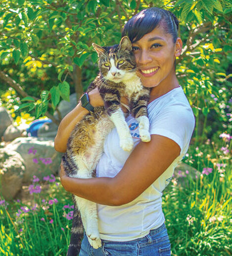 Carmel holding a cat in her arms.