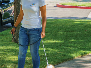 Carmel Mims walking a cute little dog.