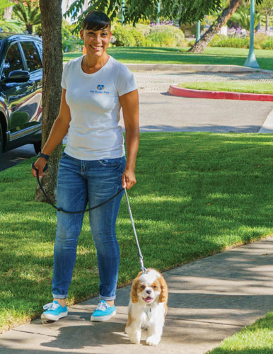 Carmel Mims walking a cute little dog.